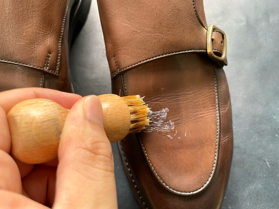 無力の靴クリームを塗布されるアンティークレザーの革靴