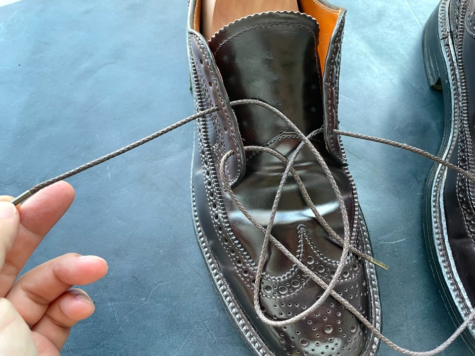 靴紐を取り付けている革靴