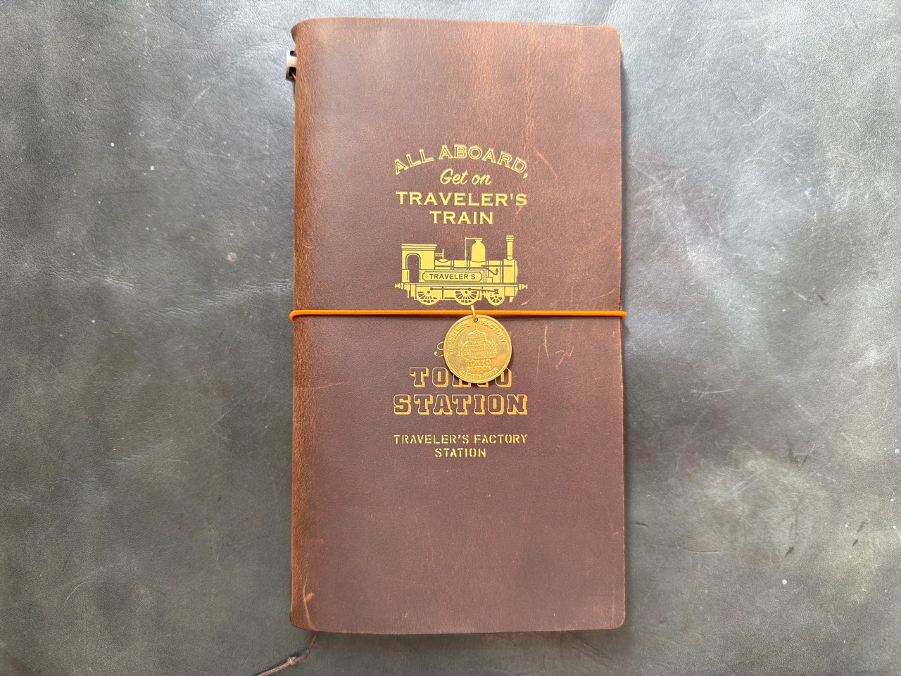 ブラスタグを取り付けたファクトリーステーションエディションのトラベラーズノート