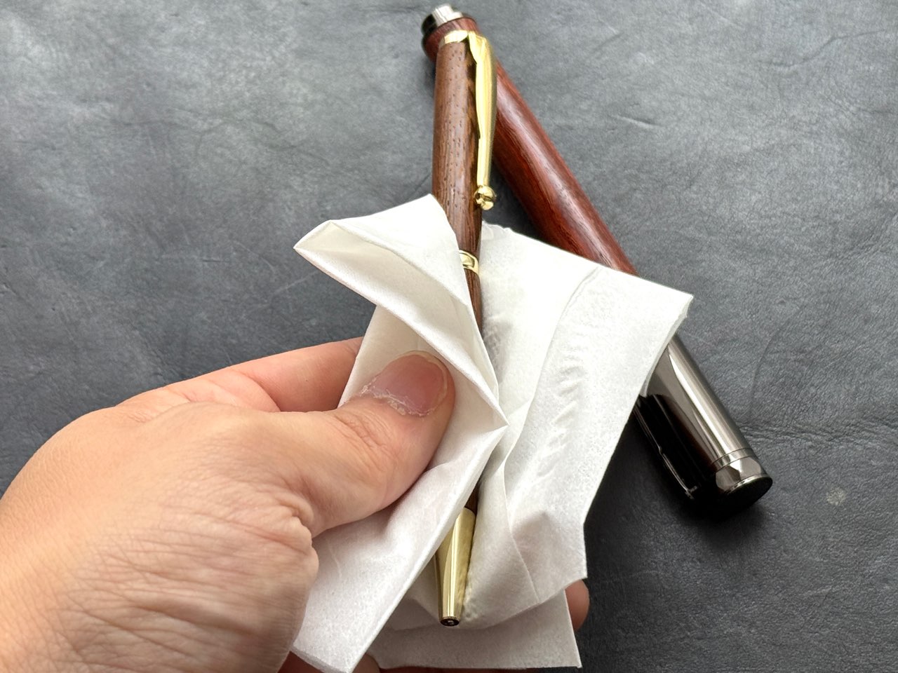 ティッシュで乾拭きしている木軸ボールペン
