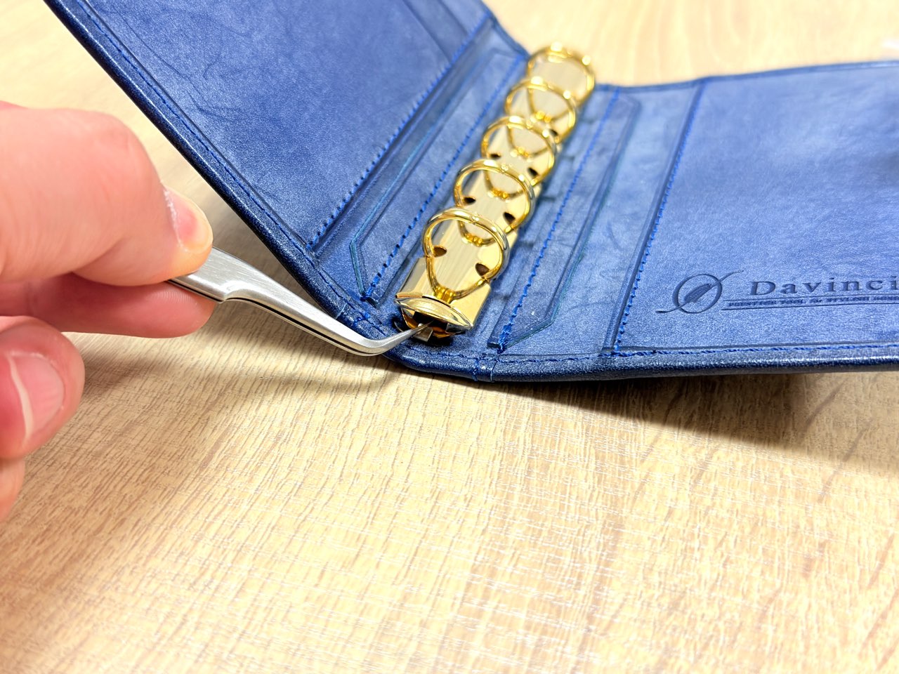 固定用爪を下ろして固定作業中のリングバインダー