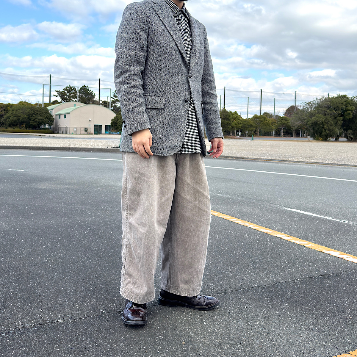 フロントボタンを留めたツイードジャケット