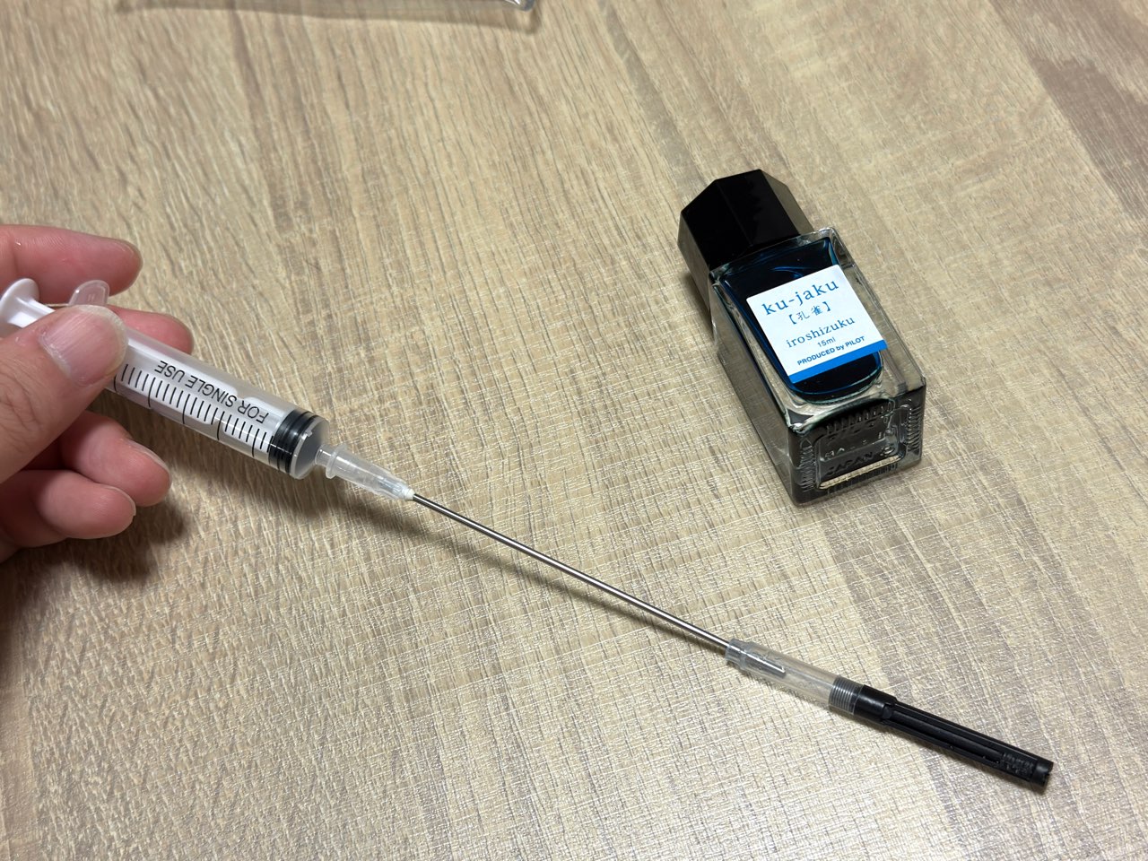 注射器でコンバーターへインクを投入する状態