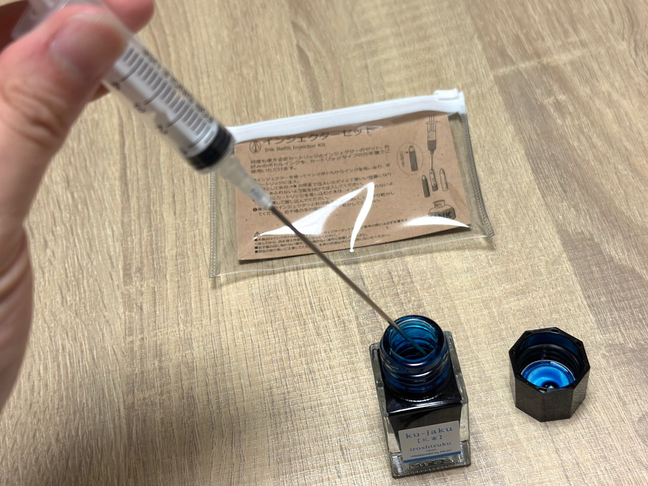 インクに射した注射器の先端