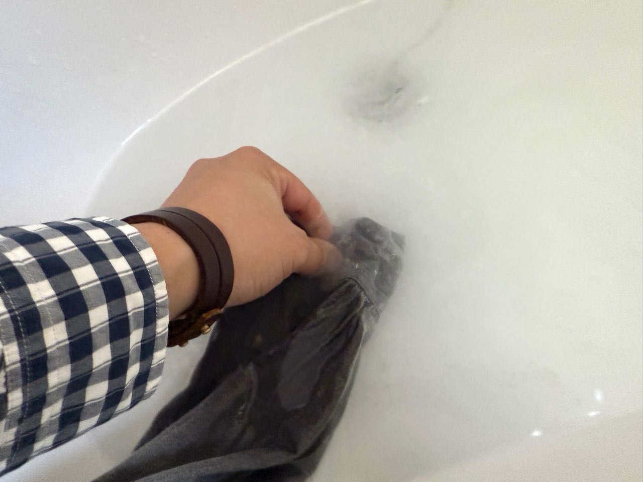 揉み洗い中のインクで汚れたシャツ