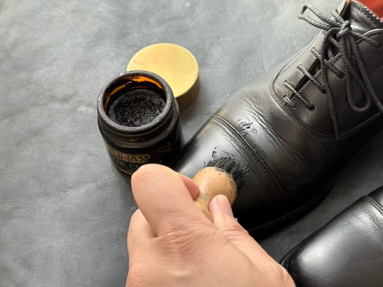 靴クリームを塗っている最中の革靴